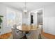 Bright dining room with a modern light fixture over a round wooden table and upholstered chairs at 201 Bluffwood Avenue, Chapel Hill, NC 27516
