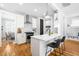Well-lit kitchen with stainless steel appliances, white cabinets, breakfast bar, and hardwood floors at 201 Bluffwood Avenue, Chapel Hill, NC 27516