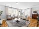 Bright living room with large windows, comfortable seating, and a decorative rug, perfect for relaxing or entertaining at 201 Bluffwood Avenue, Chapel Hill, NC 27516