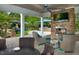 Luxurious outdoor living space with a fireplace, TV, comfortable seating, and a view of the beautifully landscaped surroundings at 201 Bluffwood Avenue, Chapel Hill, NC 27516