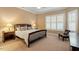 Bedroom with neutral walls, carpet, plantation shutters, and dark wood furniture at 201 Hales Wood Rd, Chapel Hill, NC 27517