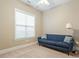 Cozy bedroom featuring a blue sofa, a ceiling fan, and a bright window, creating a serene and inviting atmosphere at 201 Hales Wood Rd, Chapel Hill, NC 27517