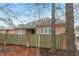 Side yard view showing well maintained fence, brick home, and mature trees at 201 Hales Wood Rd, Chapel Hill, NC 27517