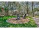 Backyard showcasing a cozy fire pit area with Adirondack chairs surrounded by lush greenery at 2401 Englewood Ave, Durham, NC 27705