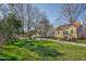 Backyard view of home with a large green lawn and mature trees under a blue sky at 2401 Englewood Ave, Durham, NC 27705