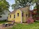 Charming yellow home with red shutters and lush landscaping, creating an inviting curb appeal at 2401 Englewood Ave, Durham, NC 27705