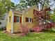 Lovely yellow home with red shutters surrounded by vibrant pink azaleas and a red Japanese maple at 2401 Englewood Ave, Durham, NC 27705