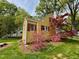 Charming yellow home with red shutters surrounded by vibrant pink azaleas and a red Japanese maple at 2401 Englewood Ave, Durham, NC 27705