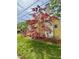 Side view of a charming yellow home with red shutters and flowering trees at 2401 Englewood Ave, Durham, NC 27705