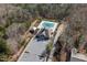 Aerial view of community pool and clubhouse surrounded by lush greenery and ample parking, with natural shade from tall trees at 253 Bendemeer Ln, Rolesville, NC 27571