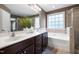 Bathroom with double sink vanity and a drop-in tub with tile surround and large window at 253 Bendemeer Ln, Rolesville, NC 27571