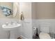 Stylish half bathroom featuring pedestal sink, round mirror, and modern fixtures at 253 Bendemeer Ln, Rolesville, NC 27571