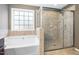 Bathroom features a soaking tub with a shower and a window for natural light at 253 Bendemeer Ln, Rolesville, NC 27571