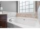 Bathtub showcasing a tile surround and a bright window, creating a relaxing bath space at 253 Bendemeer Ln, Rolesville, NC 27571