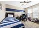 Cozy bedroom boasts natural light from a window, and a sporty blue accent stripe at 253 Bendemeer Ln, Rolesville, NC 27571