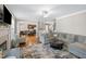 Open-concept living room featuring a comfortable gray sofa, ceiling fan, and hardwood floors at 253 Bendemeer Ln, Rolesville, NC 27571