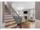 Staircase with wood treads and decorative iron railings leading to a living room with a fireplace at 253 Bendemeer Ln, Rolesville, NC 27571