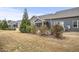 Back of townhomes featuring gray siding, screened porches, dry grass, and shrubs at 255 Thornwhistle Pl, Garner, NC 27529