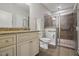 Well-lit bathroom featuring a granite countertop vanity and a tiled walk-in shower with glass doors at 255 Thornwhistle Pl, Garner, NC 27529