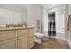 Well-lit bathroom features tile floors, vanity with granite countertop, toilet, and tiled shower with curtain at 255 Thornwhistle Pl, Garner, NC 27529