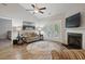 Cozy living room with a fireplace, ceiling fan, wood floors, and comfortable seating at 255 Thornwhistle Pl, Garner, NC 27529