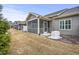 Back of townhomes with screened porches, gray siding, generator and dry grass at 255 Thornwhistle Pl, Garner, NC 27529