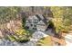 Overhead view of a home surrounded by lush trees, with a driveway leading to an attached garage and well-maintained lawn at 260 Crestdale Dr, Clayton, NC 27520