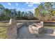 Backyard with a stone fire pit surrounded by mature trees and a large grassy area at 260 Crestdale Dr, Clayton, NC 27520