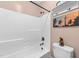 Bathroom showcasing a bathtub with shower, white tile, and coastal decor at 260 Crestdale Dr, Clayton, NC 27520