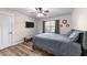 Well-lit bedroom with wood flooring, a large window, and a mounted television at 260 Crestdale Dr, Clayton, NC 27520
