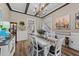 Traditional dining room with hardwood floors, wood beam ceiling, white wainscoting, and access to the kitchen at 260 Crestdale Dr, Clayton, NC 27520