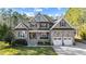 Charming two-story home featuring a stone facade, covered front porch, and an attached two-car garage at 260 Crestdale Dr, Clayton, NC 27520