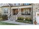 Charming front porch showcasing stone details, white columns, and cozy outdoor seating area for relaxing at 260 Crestdale Dr, Clayton, NC 27520