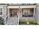 Inviting covered front porch featuring stone accents, decorative columns, and comfortable seating area at 260 Crestdale Dr, Clayton, NC 27520