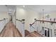Upstairs hallway showcasing wood floors, staircase, and modern lighting fixture at 260 Crestdale Dr, Clayton, NC 27520