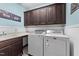 Functional laundry room with washer, dryer, sink, and ample storage cabinets at 260 Crestdale Dr, Clayton, NC 27520