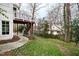 Landscaped backyard with a patio, lush grass, and a charming staircase to a deck, perfect for outdoor entertaining at 2635 Lakeview Dr, Raleigh, NC 27609