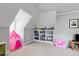 Bright bonus room featuring sloped ceilings, a play tent, custom shelving and storage, and playful decor at 2635 Lakeview Dr, Raleigh, NC 27609