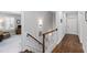 Well-lit hallway with hardwood floors, elegant staircase, and decorative sconces at 2635 Lakeview Dr, Raleigh, NC 27609