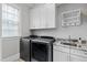 Bright laundry room with sink, granite countertops, custom cabinetry and folding rack for convenience at 2635 Lakeview Dr, Raleigh, NC 27609