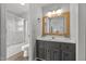 Well-lit bathroom featuring a gray vanity with a white countertop and a shower with sliding glass doors at 309 Old Farm Dr, Graham, NC 27253