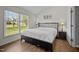 Serene bedroom with hardwood floors, a large window, and a comfortable bed with nightstands at 309 Old Farm Dr, Graham, NC 27253