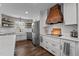 Modern kitchen with white cabinets, stainless steel appliances, and a wooden range hood at 309 Old Farm Dr, Graham, NC 27253