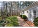 Well-maintained backyard with a brick pathway, lush green lawn, and mature trees at 3508 Cambridge Rd, Durham, NC 27707