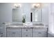 Bathroom featuring a double vanity with granite countertops, white cabinets, and decorative lighting at 3508 Cambridge Rd, Durham, NC 27707