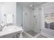 A stylish bathroom featuring a glass-enclosed shower, pedestal sink, and blue accent wall at 3508 Cambridge Rd, Durham, NC 27707