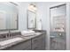 Bathroom featuring a double vanity with granite countertops, modern mirrors, and soft lighting at 3508 Cambridge Rd, Durham, NC 27707