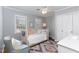 Cozy bedroom with pastel-colored furniture, bright windows, and a unique patterned rug at 3508 Cambridge Rd, Durham, NC 27707