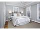 Bright bedroom with gray walls, plush carpet, and a wrought iron bed frame with white bedding at 3508 Cambridge Rd, Durham, NC 27707