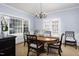 Elegant dining room with a round wooden table, decorative chandelier, and a large window at 3508 Cambridge Rd, Durham, NC 27707